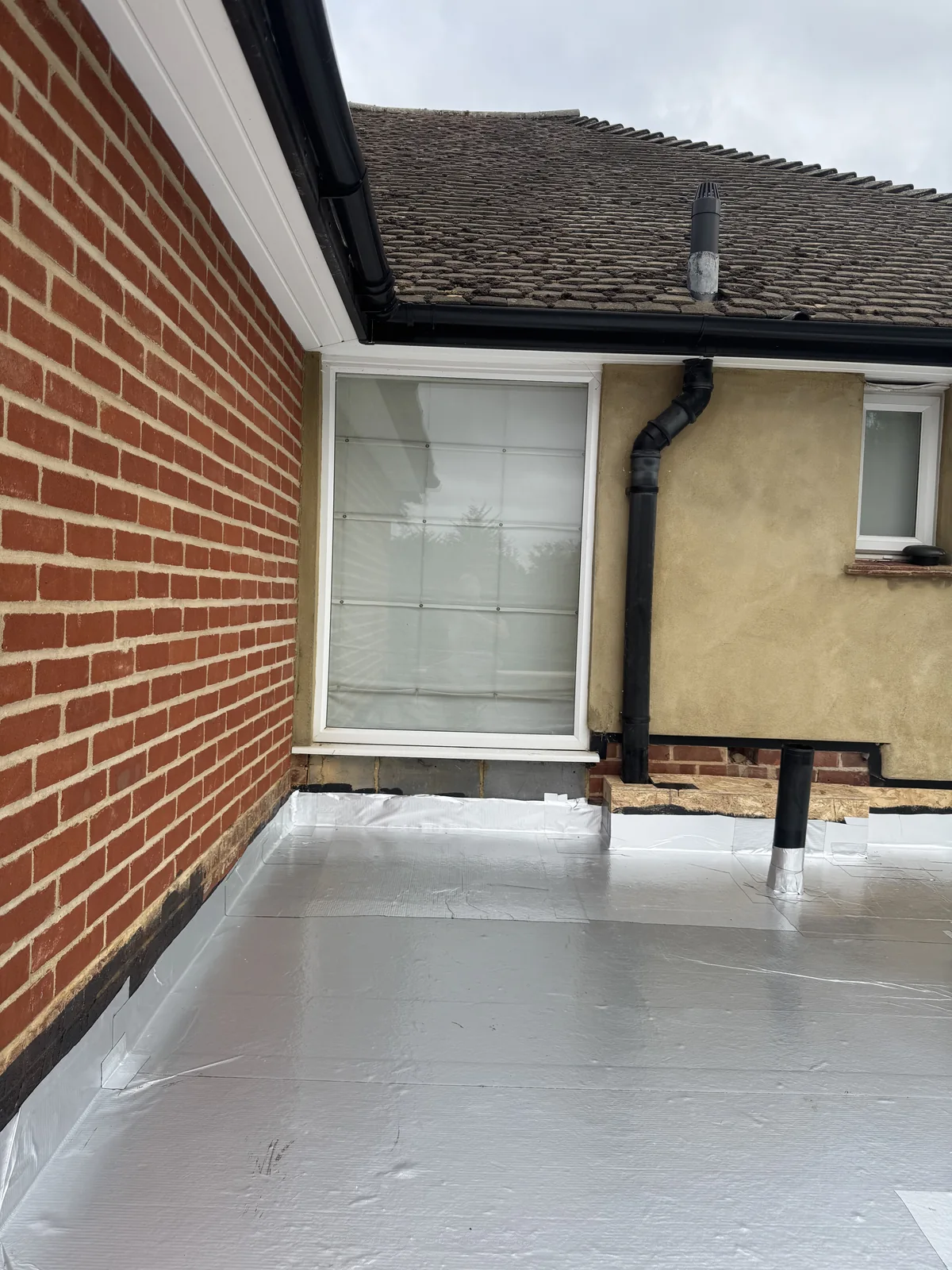 Alutrix vapour control layer installed across the Cobham flat roof deck and upstands
