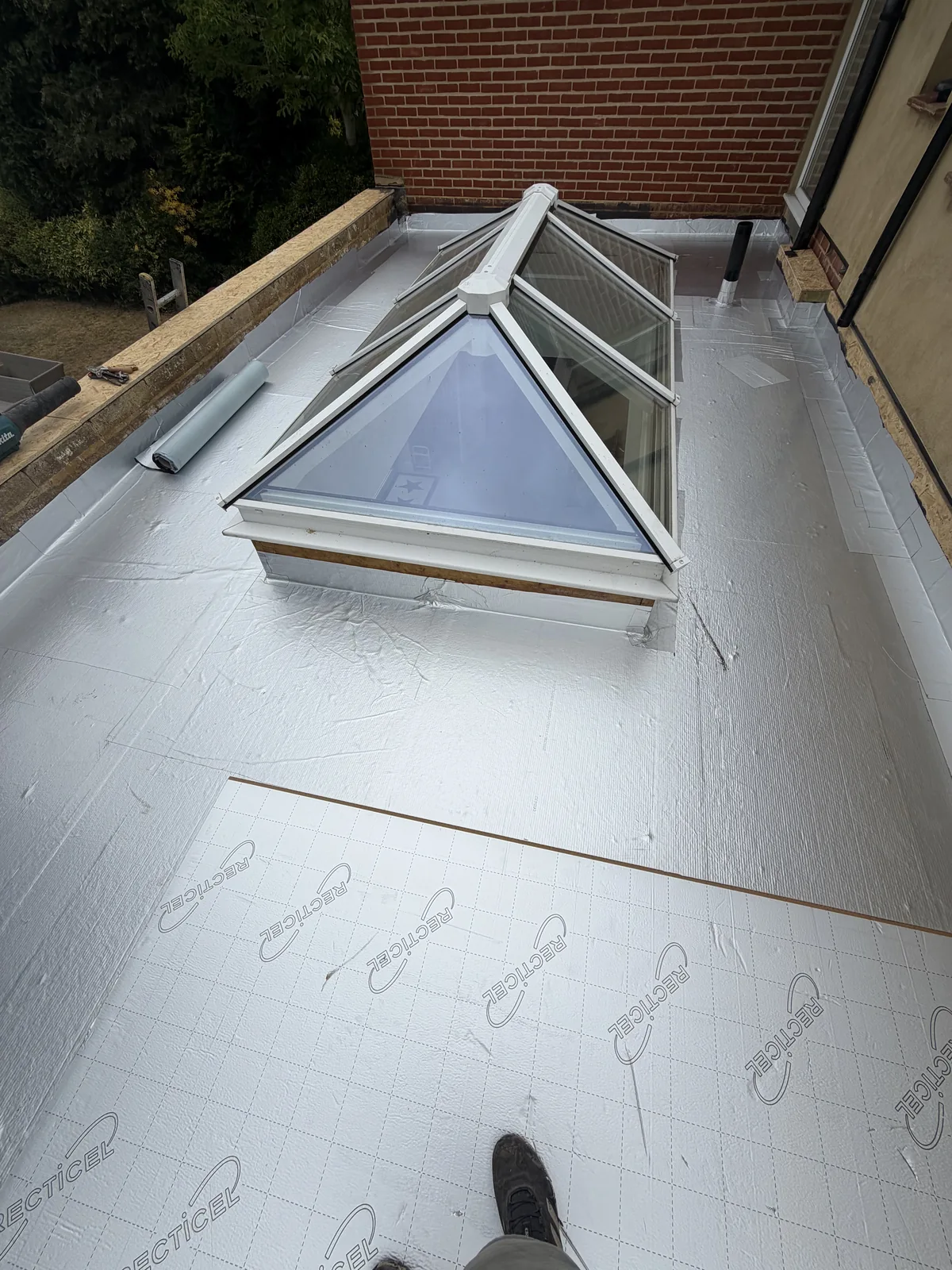 PIR insulation being fitted above the vapour control layer around the roof lantern