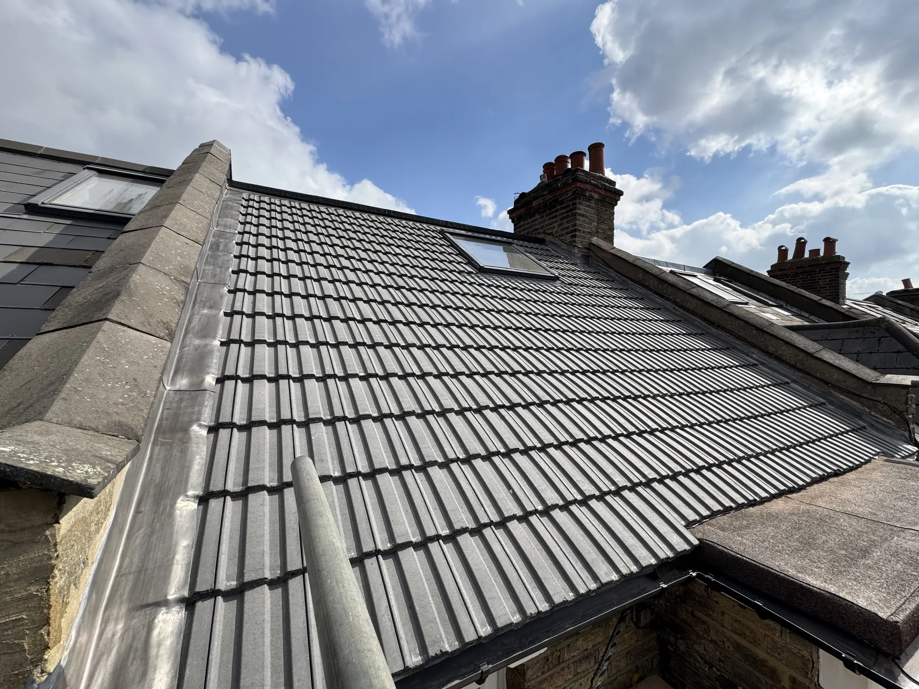 Completed grey tiled roof replacement in Raynes Park