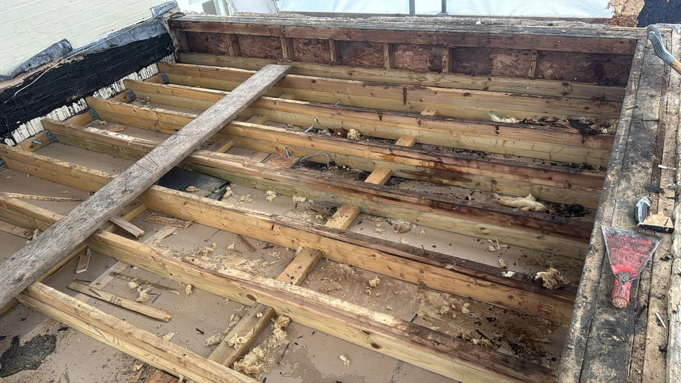 Exposed timber roof structure during the cold-deck flat roof work in Redhill
