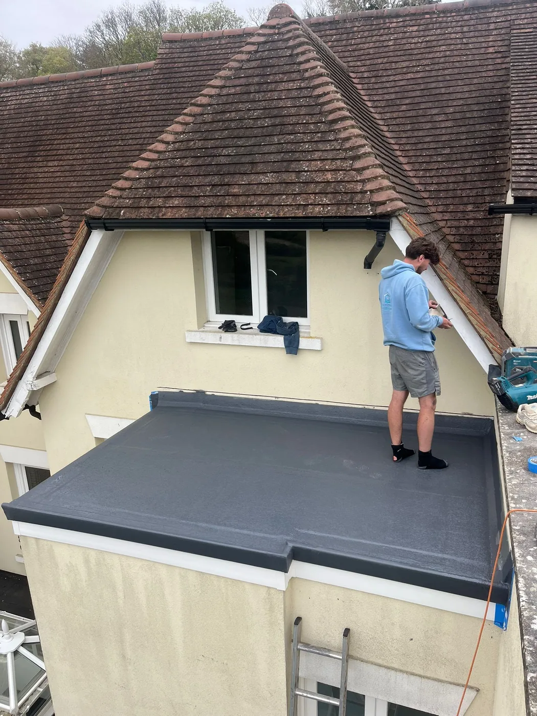 Completed smaller warm-deck GRP flat roof with dark grey finish in Redhill