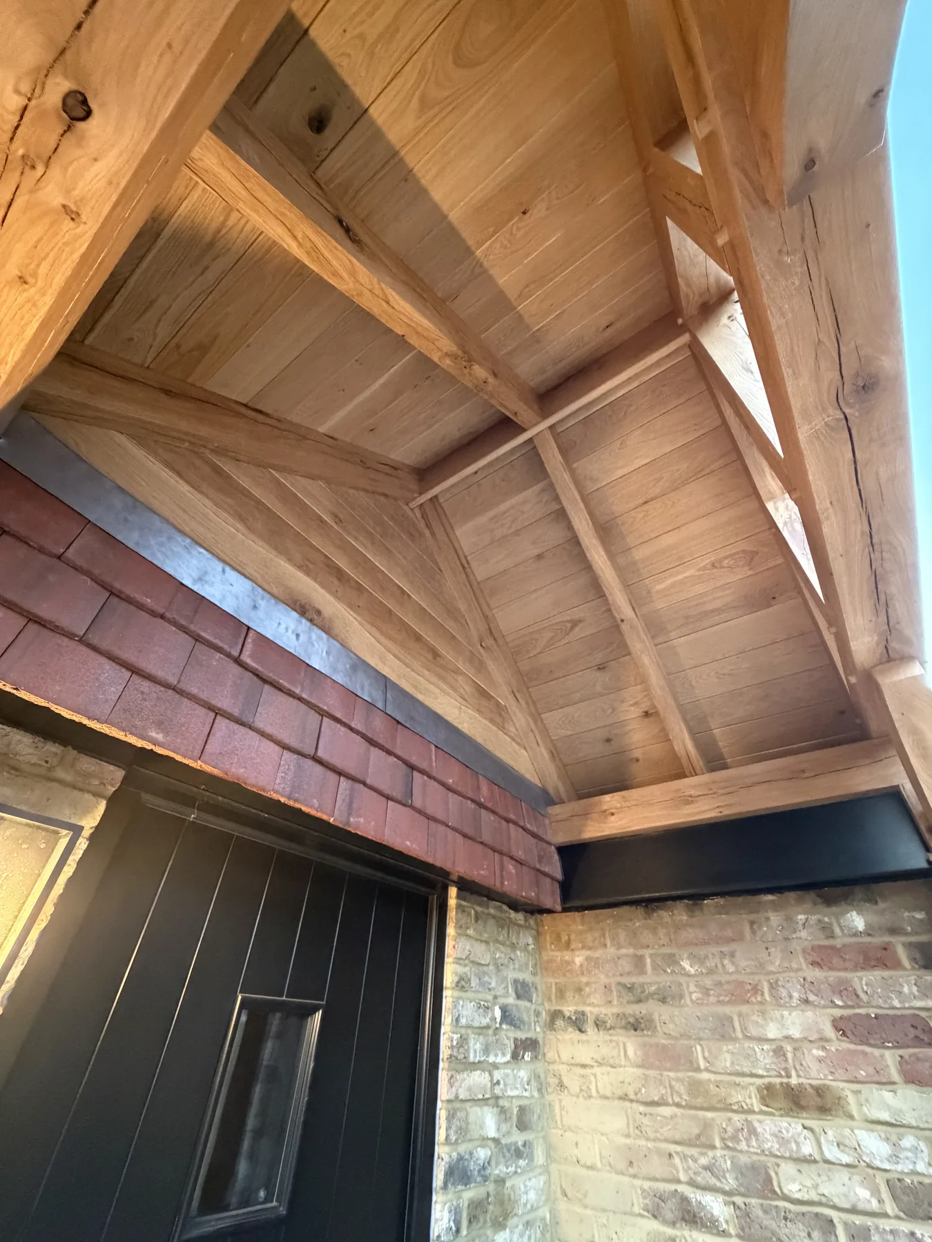 Oak porch underside with Code 5 leadwork and hanging-tile junction in West End, Surrey